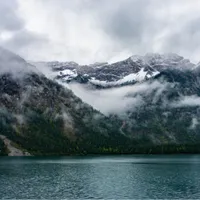 Snowy mountains in the fog at Plansee lake   Shower Curtain