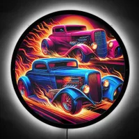 Vintage hotrods racing under a fiery sunset LED sign