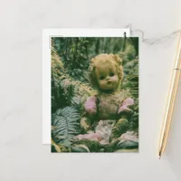 An abandoned doll in the forest postcard