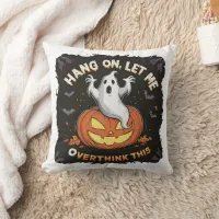 A playful ghost pondering above a jack-o'-lantern throw pillow