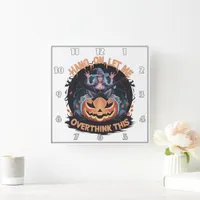 Enigmatic witch pondering atop a pumpkin at dusk square wall clock